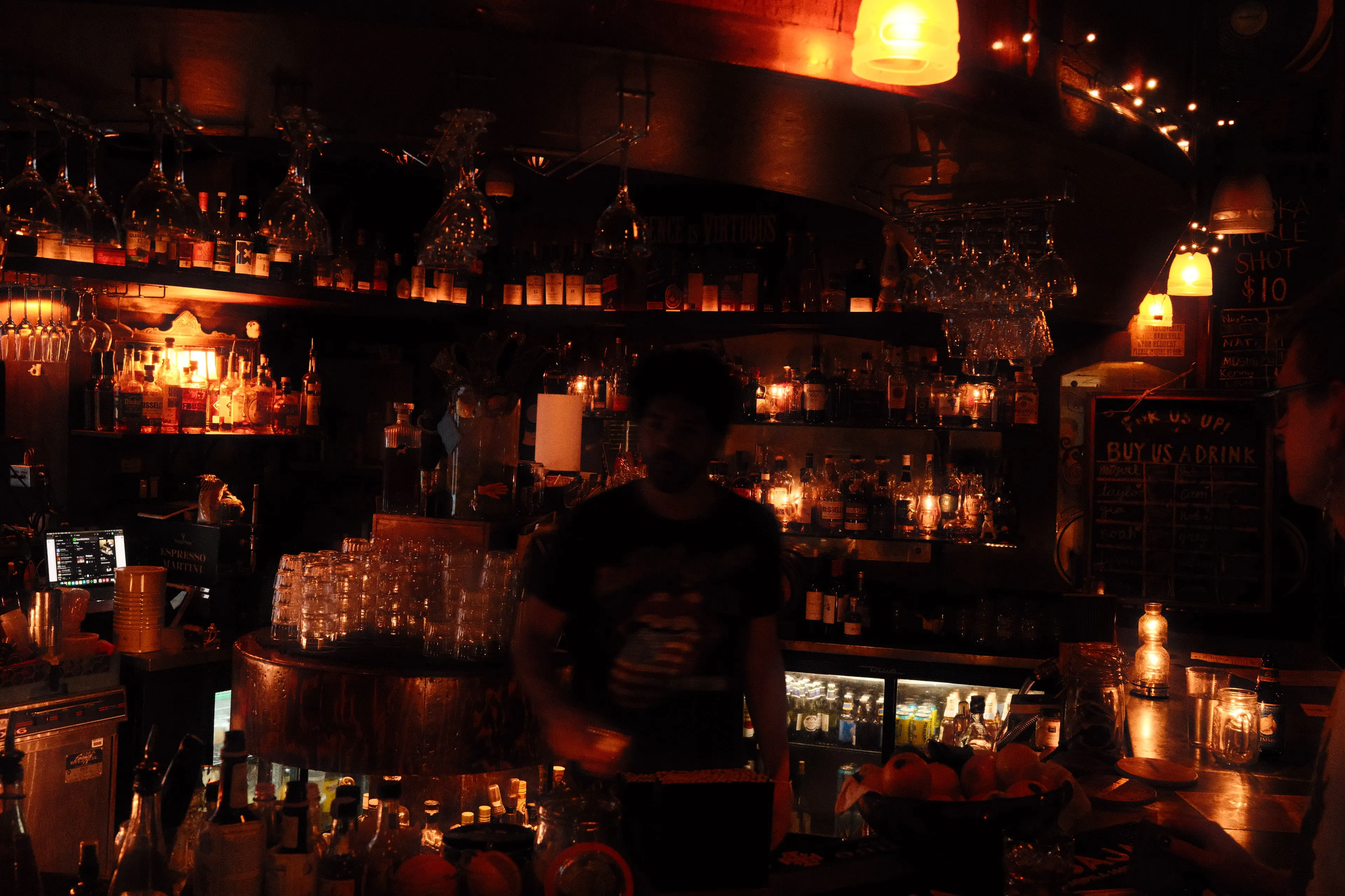 back lit bartender in candle light