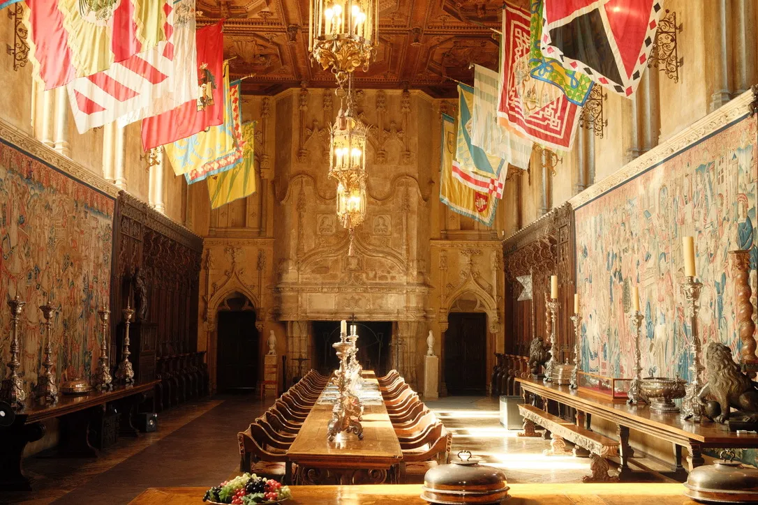 Grand dining hall with tapestries and chandeliers