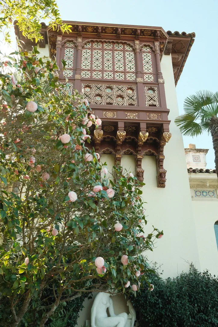 Ornate balcony with camellias and statue