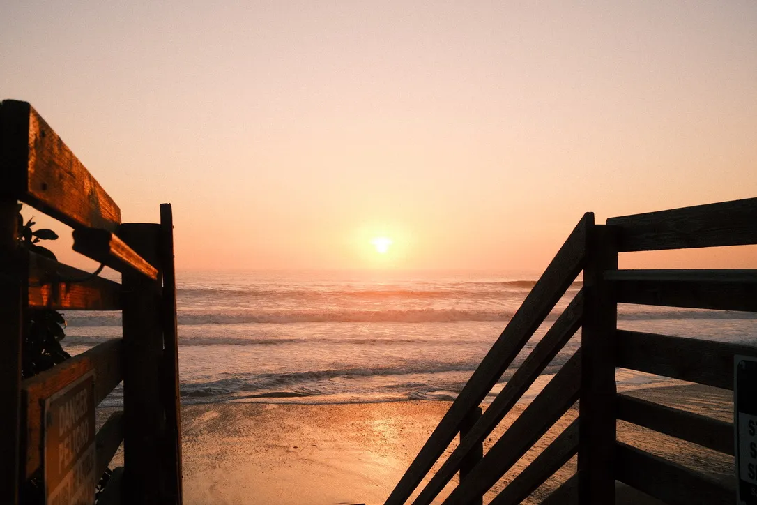 Sunset over the ocean from wooden stairs