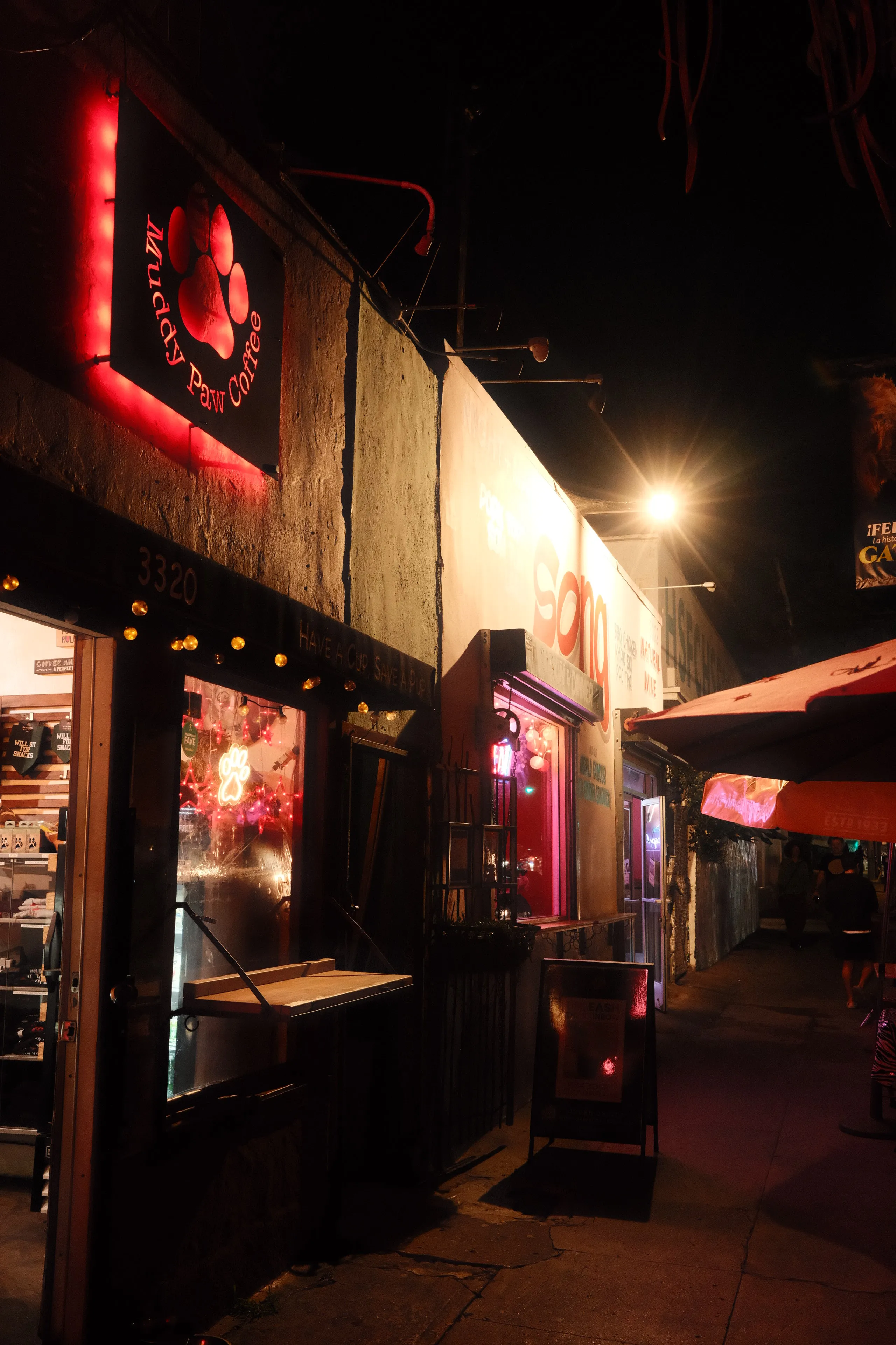 Neon-lit storefronts on Sunset Boulevard at night
